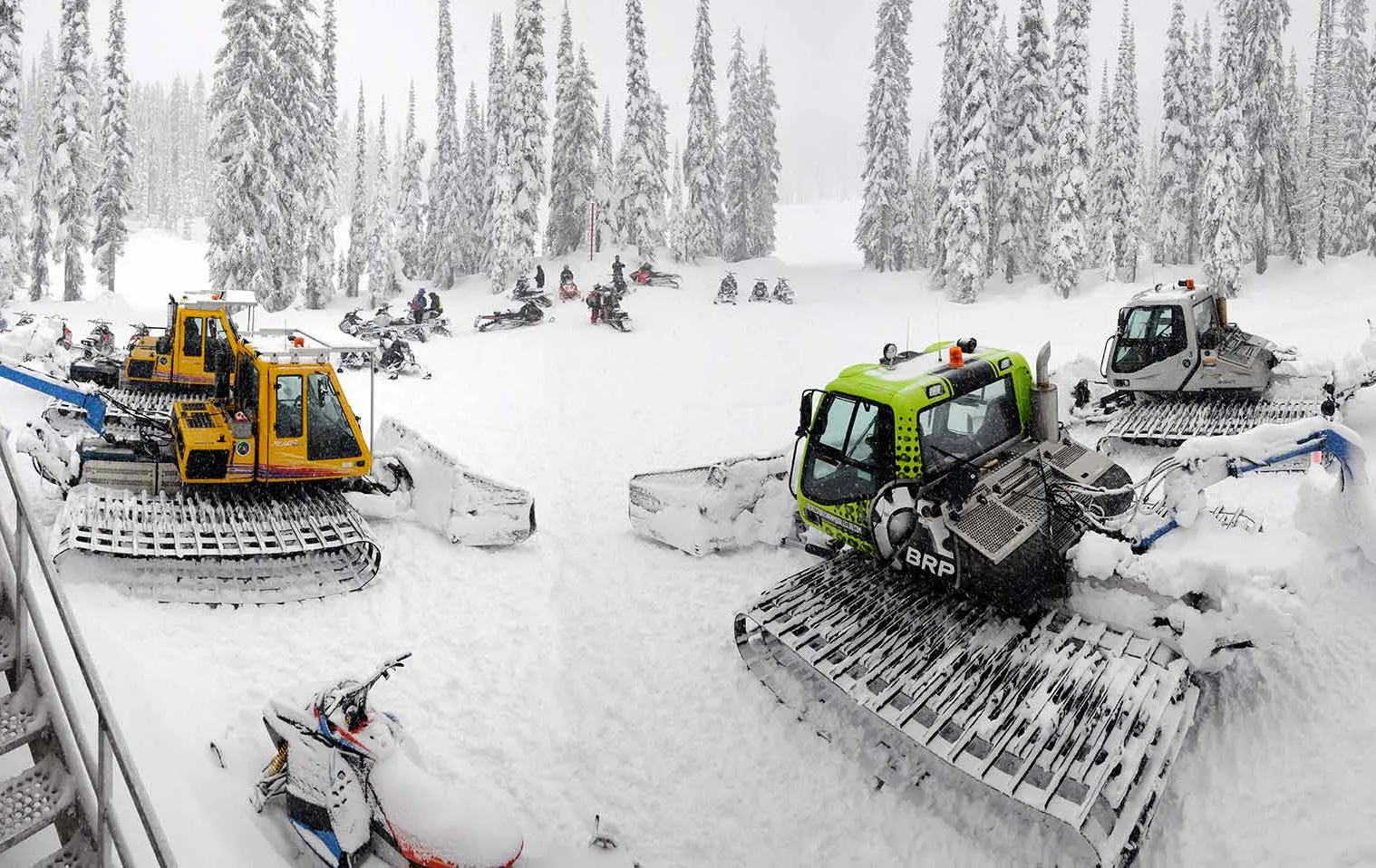 Grooming machines parked in the snow in a half circle