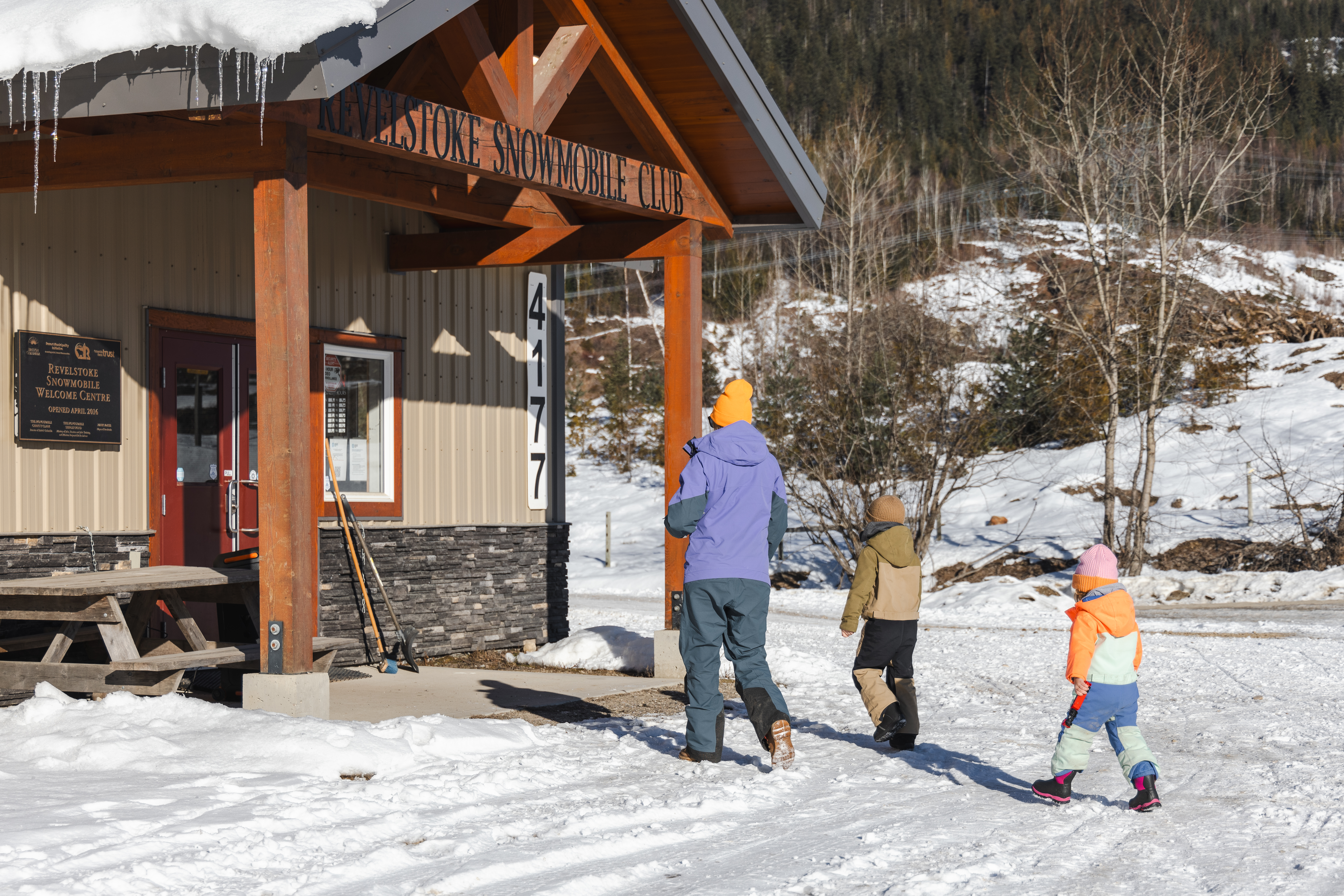 A family walks to the entrance of the Revelstoke Snowmobile Club